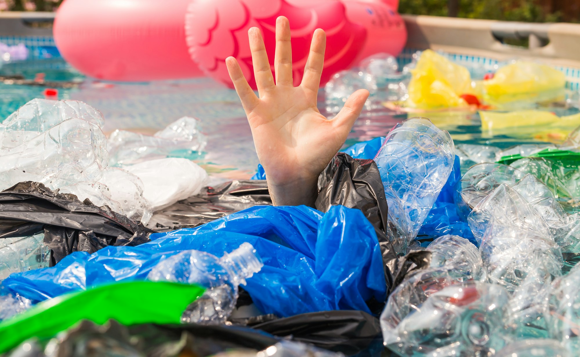 Plastic pollution and environmental problem, man's hand in plastic sea